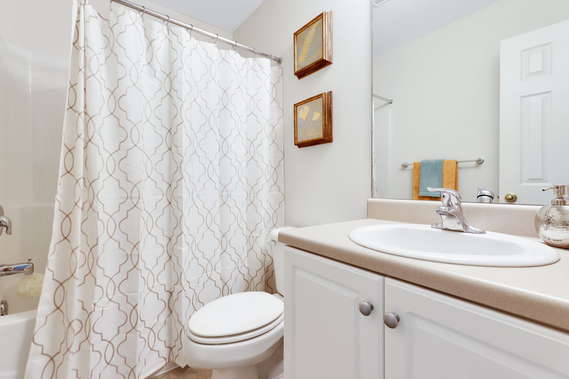 A bathroom with a toilet , sink , and shower curtain.