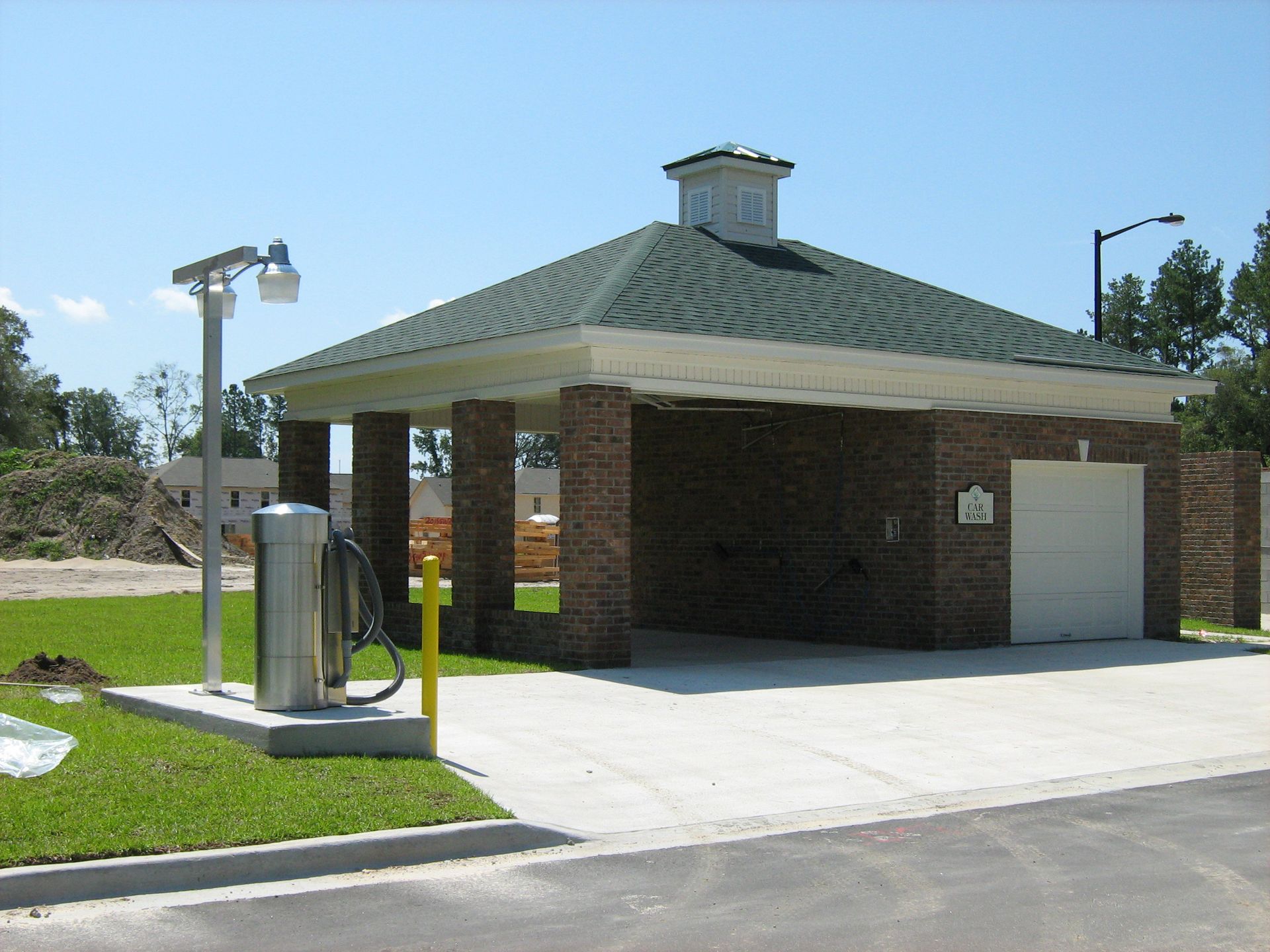 A brick building with a green roof and a white garage door