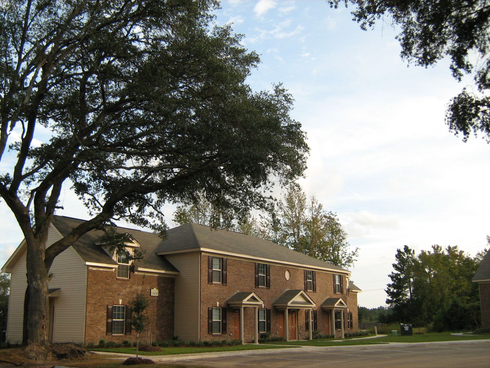 A brick apartment building with a tree in front of it