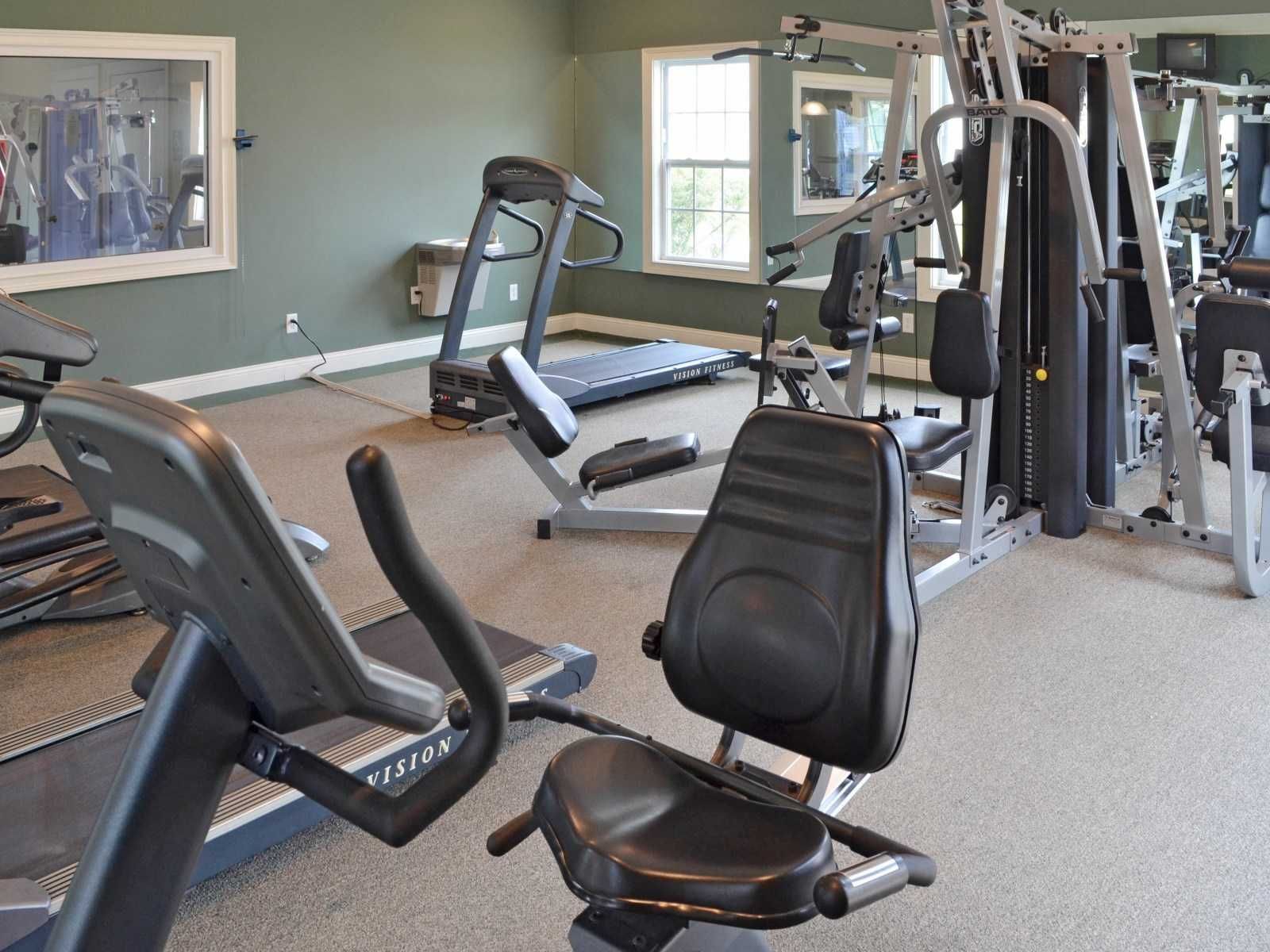 A gym with a treadmill and a recumbent bike