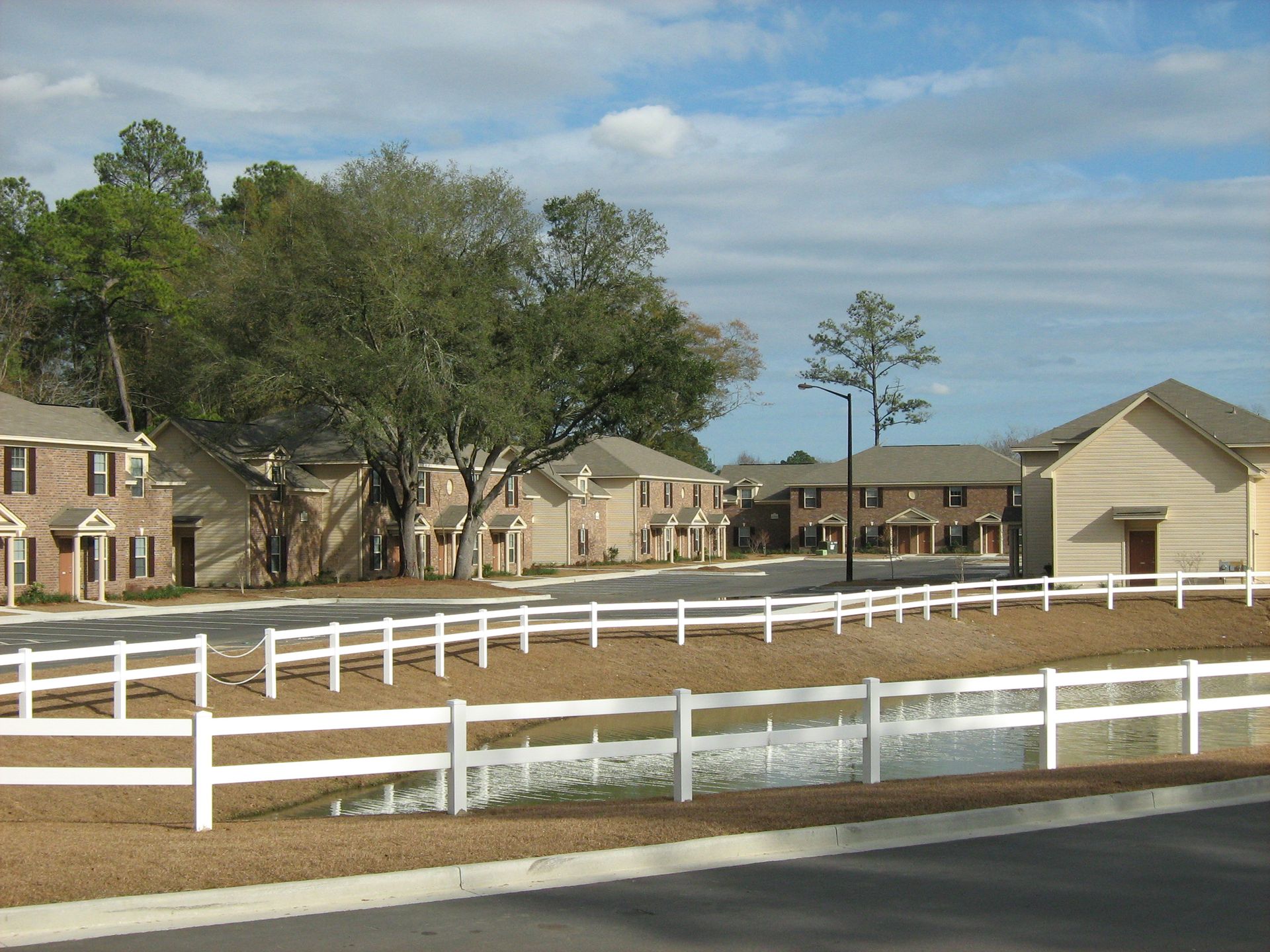 A row of houses with a white fence in front of them