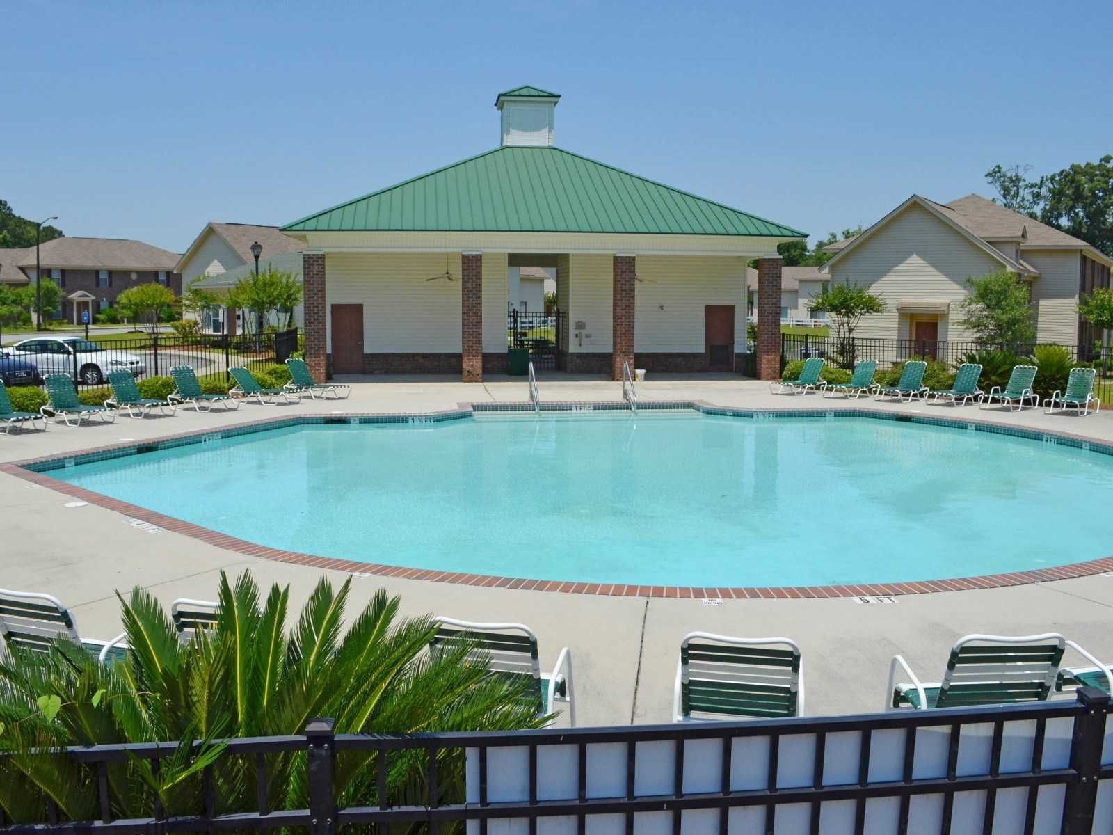 A large swimming pool in front of a building with a green roof