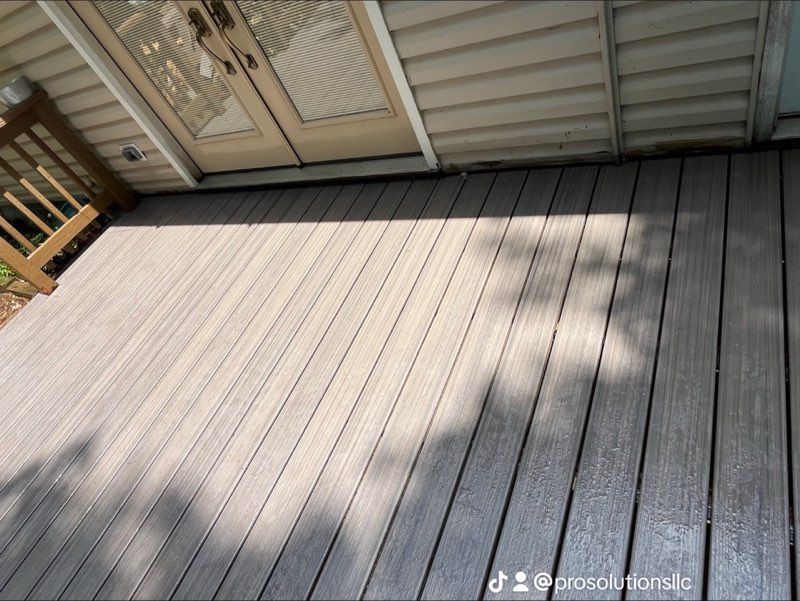 White deck with railing, supported by wooden posts. Red wire runs beneath deck.
