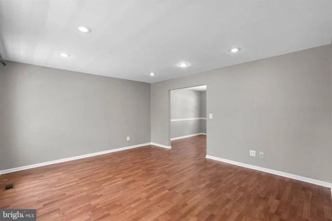 Hardwood floor in a room, with a window and white door visible.