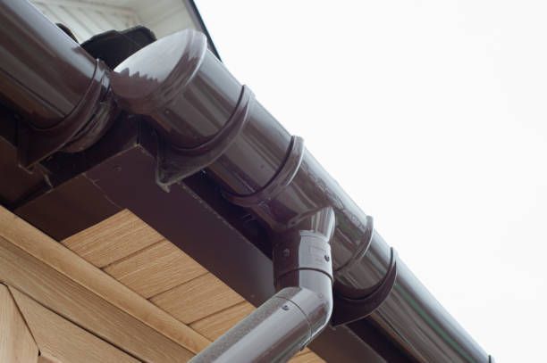 Gutter with downpipe on the roof of a house installed by Majestic Mountain Seamless Gutters in Evergreen, MT