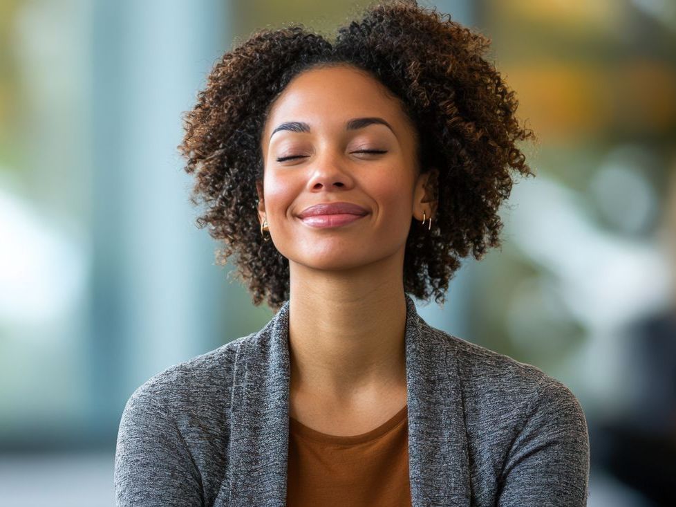 A woman is smiling with her eyes closed.