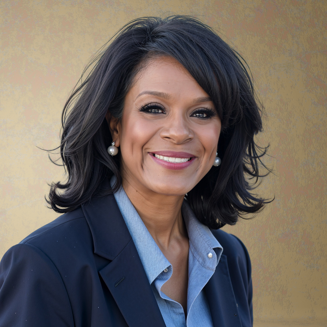 A woman wearing glasses and a suit is smiling.