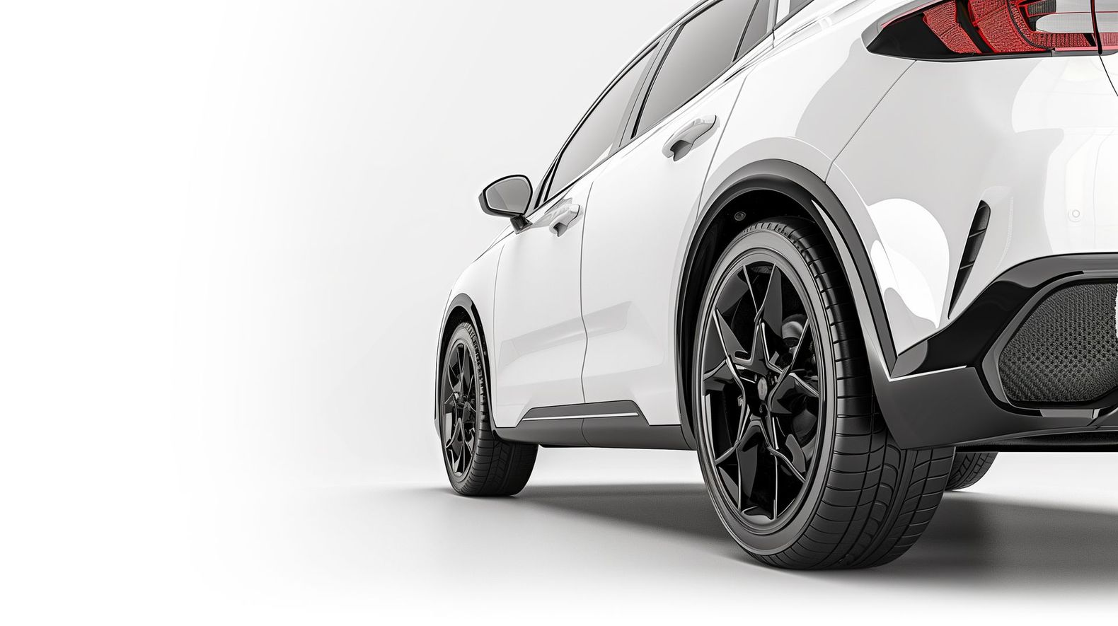 A white car with black wheels and tires on a white background.