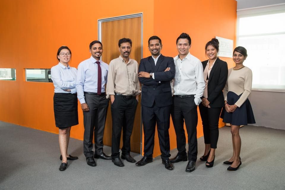 A group of people are posing for a picture in an office.