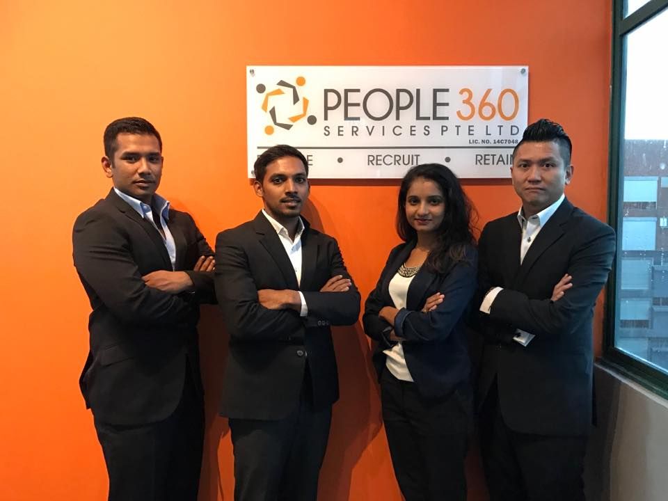 A group of people standing in front of a sign that says people 360 services pte ltd