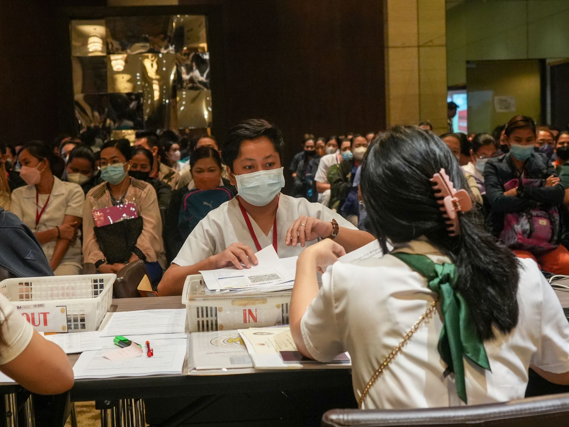 A group of people wearing face masks are sitting at a table.