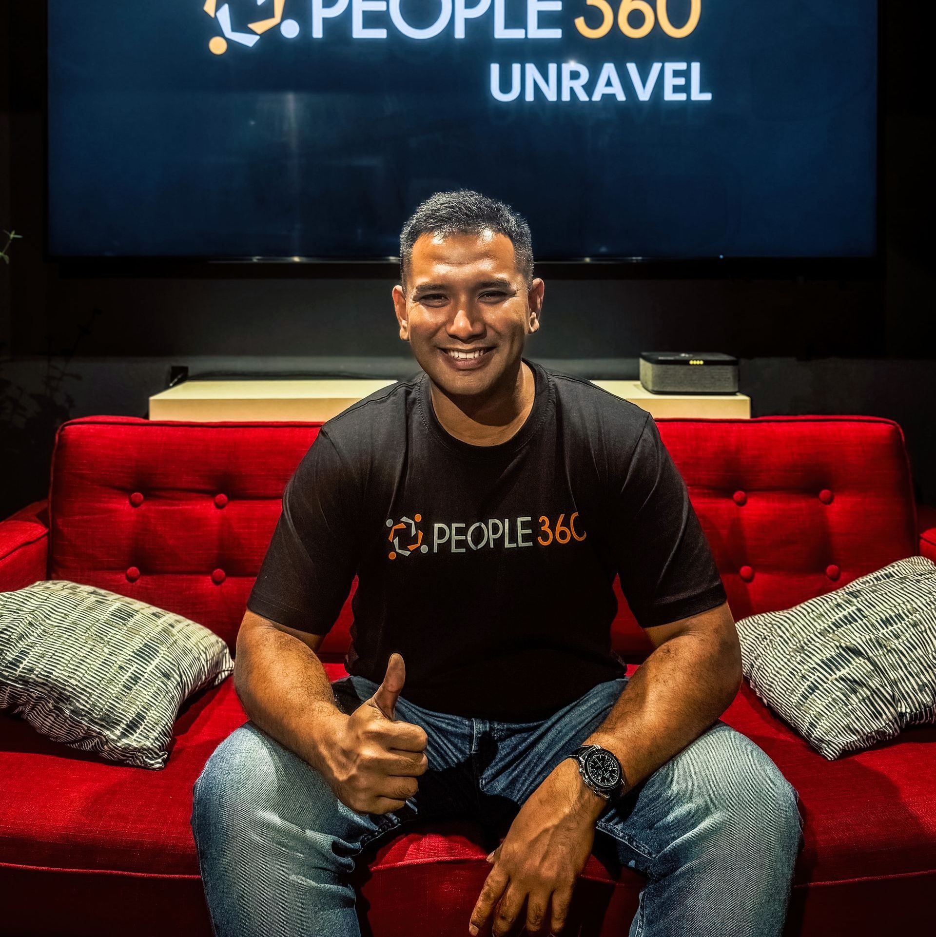 A group of people are posing for a picture while sitting on a couch.