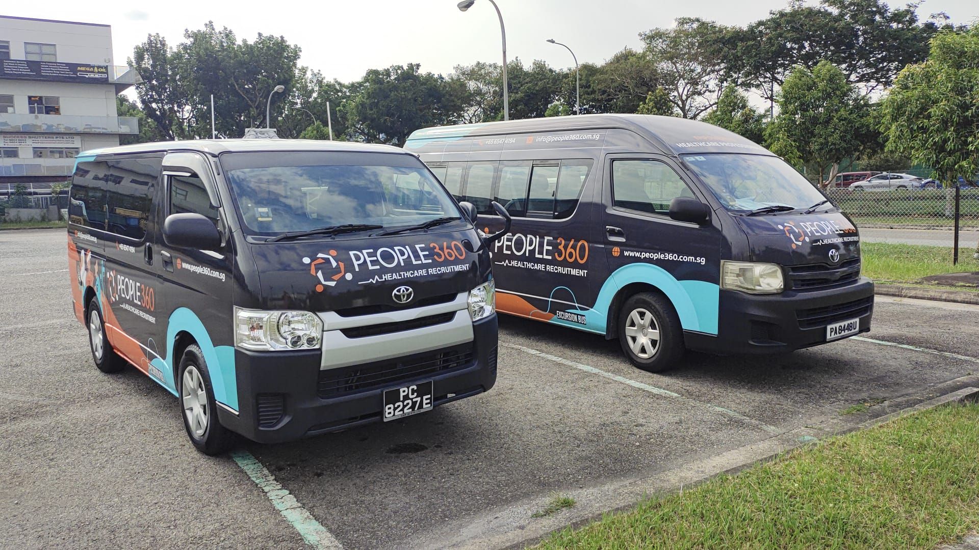 Two vans are parked next to each other in a parking lot.
