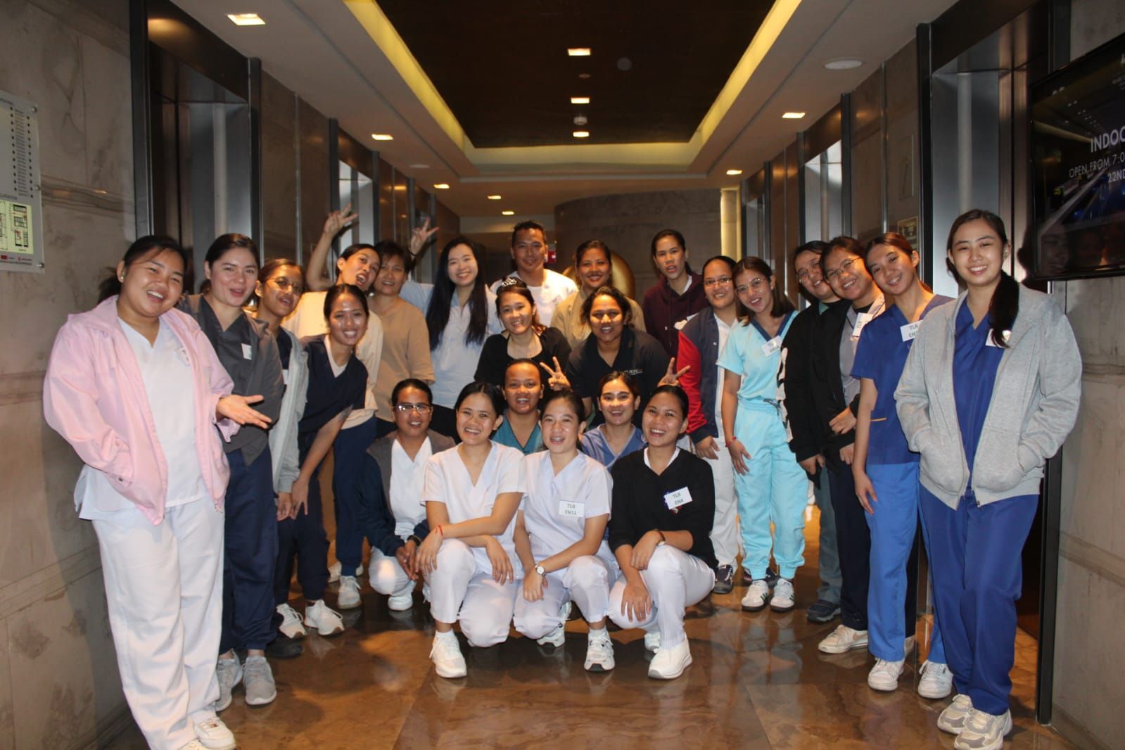 A group of nurses are posing for a picture in a hallway.