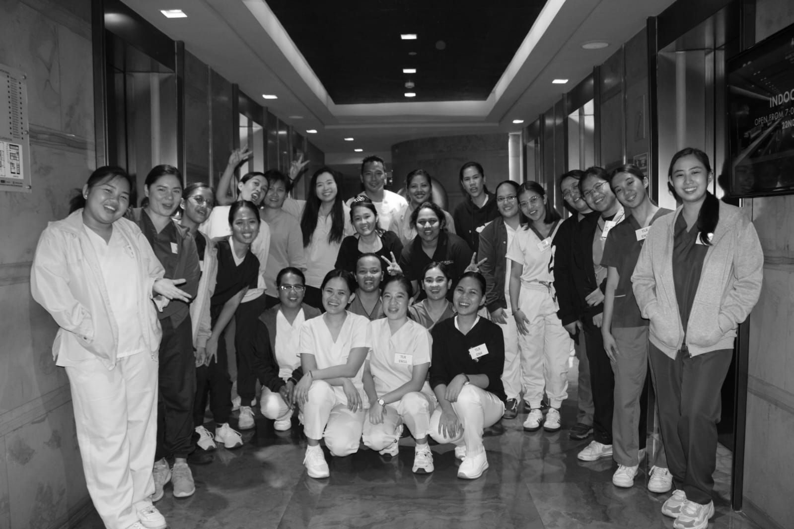 A group of people are posing for a picture in a hallway.