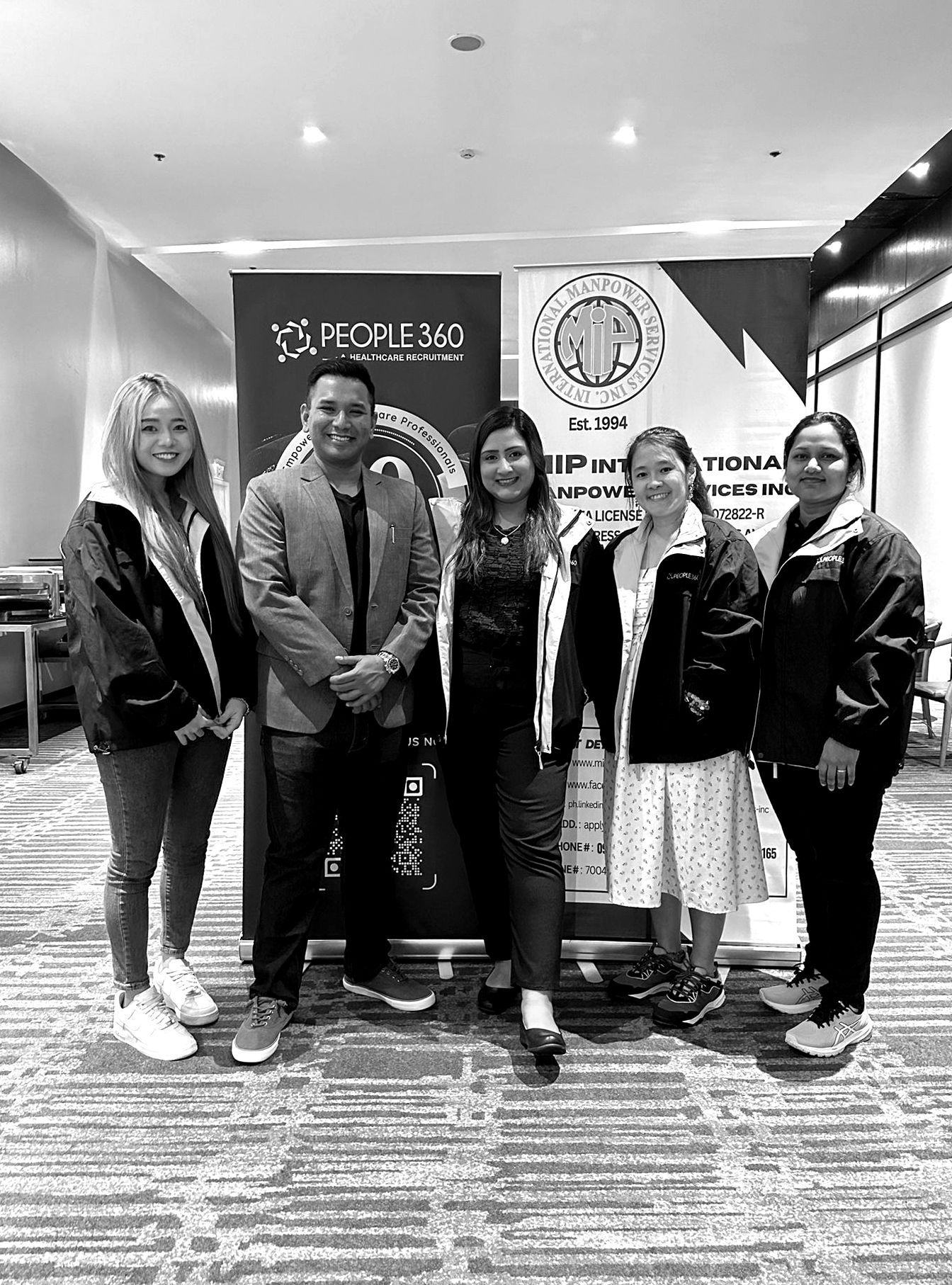 A group of people are posing for a picture in a black and white photo.