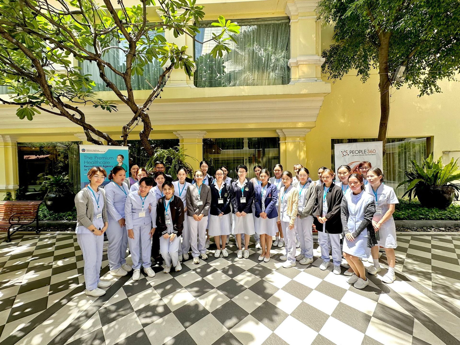 A group of people are posing for a picture in front of a building.