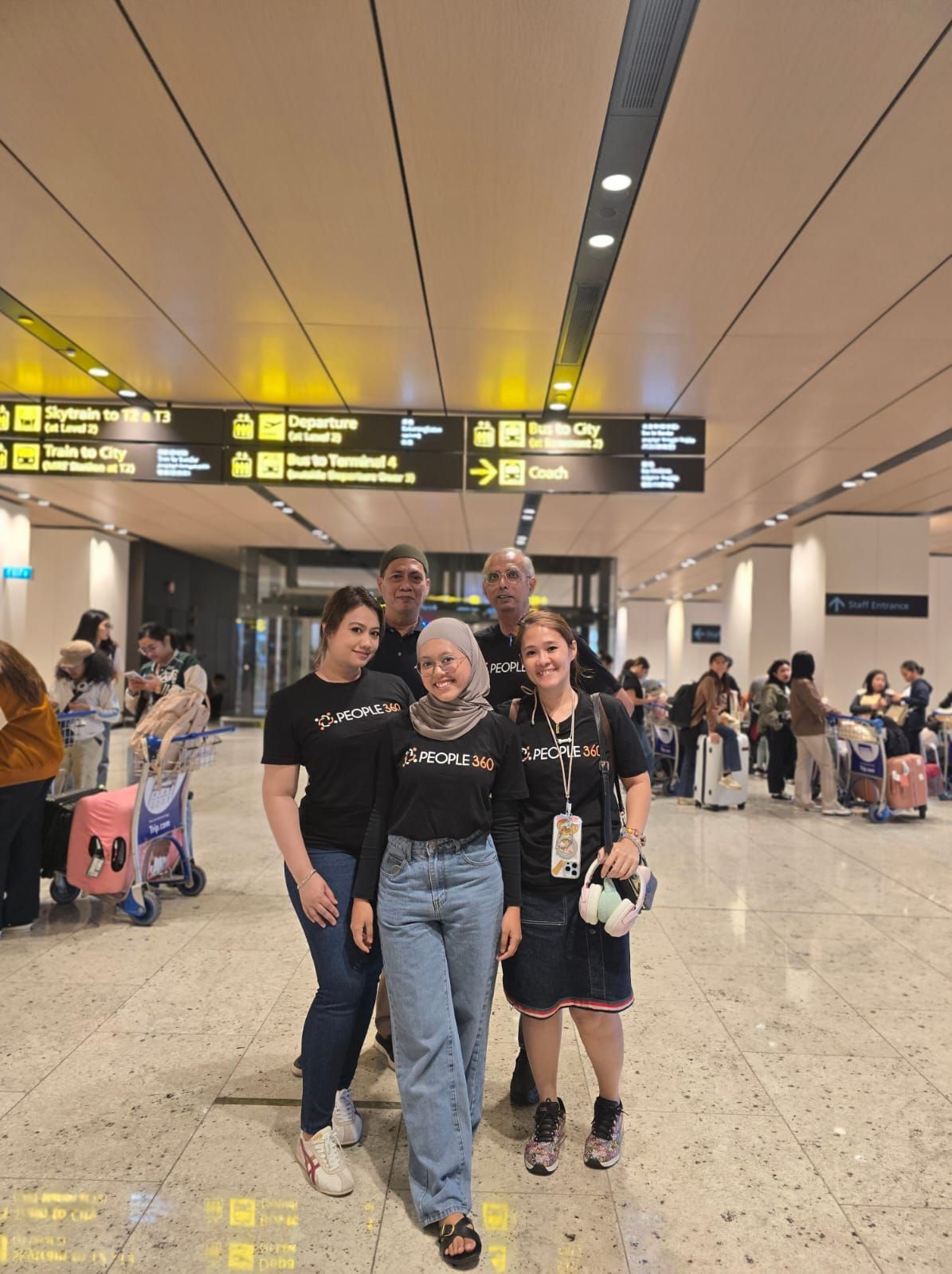 A group of people are posing for a picture in an airport.