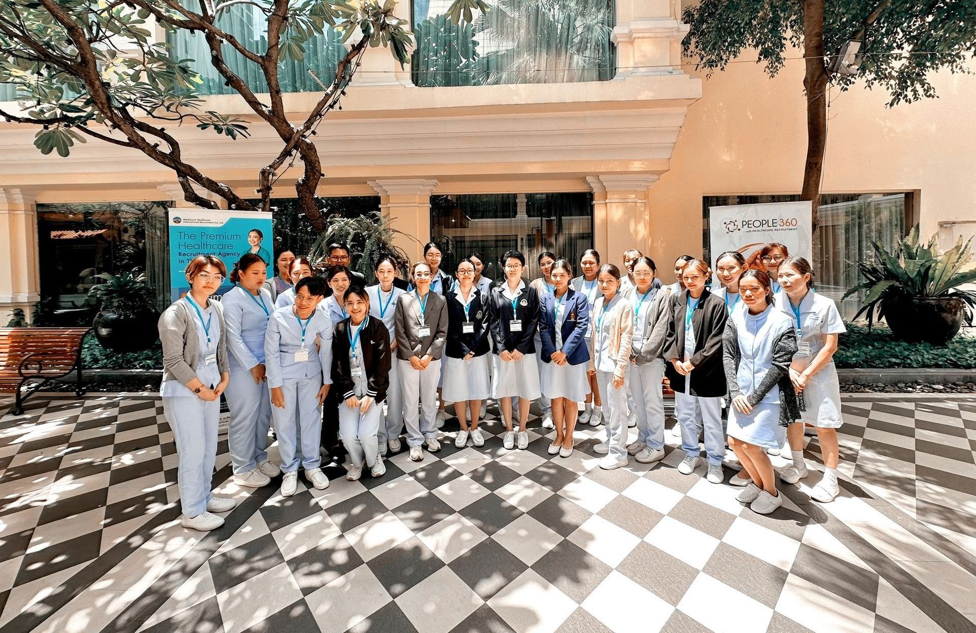 A group of people are posing for a picture in front of a building.
