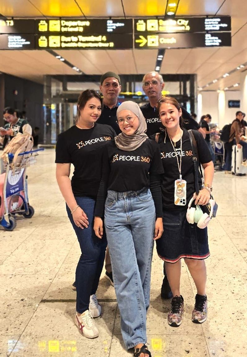 A group of people are posing for a picture at an airport.