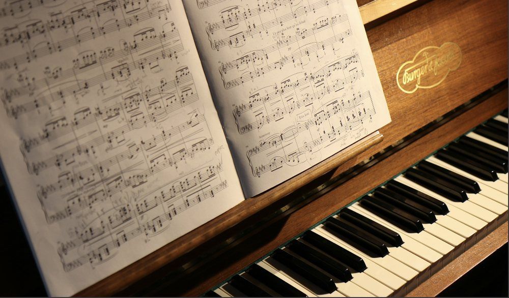 A close up of a piano with sheet music on it