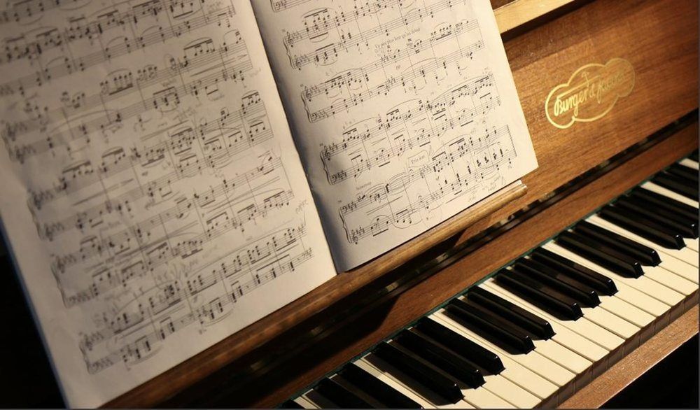 A piano with a sheet of music on top of it