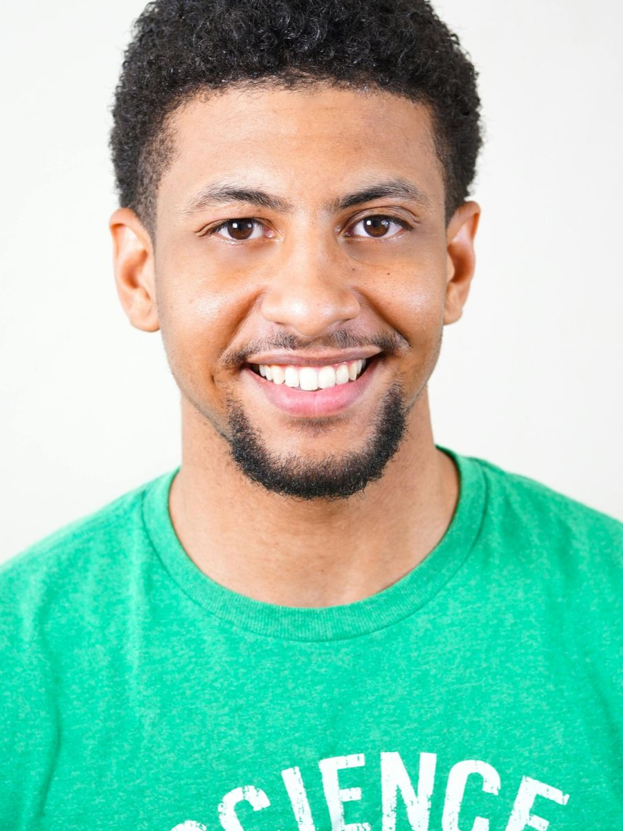 Man with a goatee smiling, wearing a green t-shirt, facing the camera.