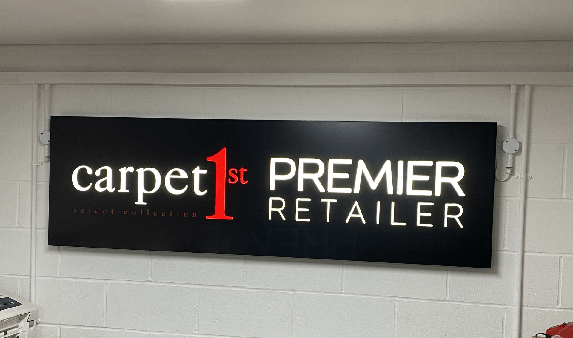 Black sign on a white wall. 