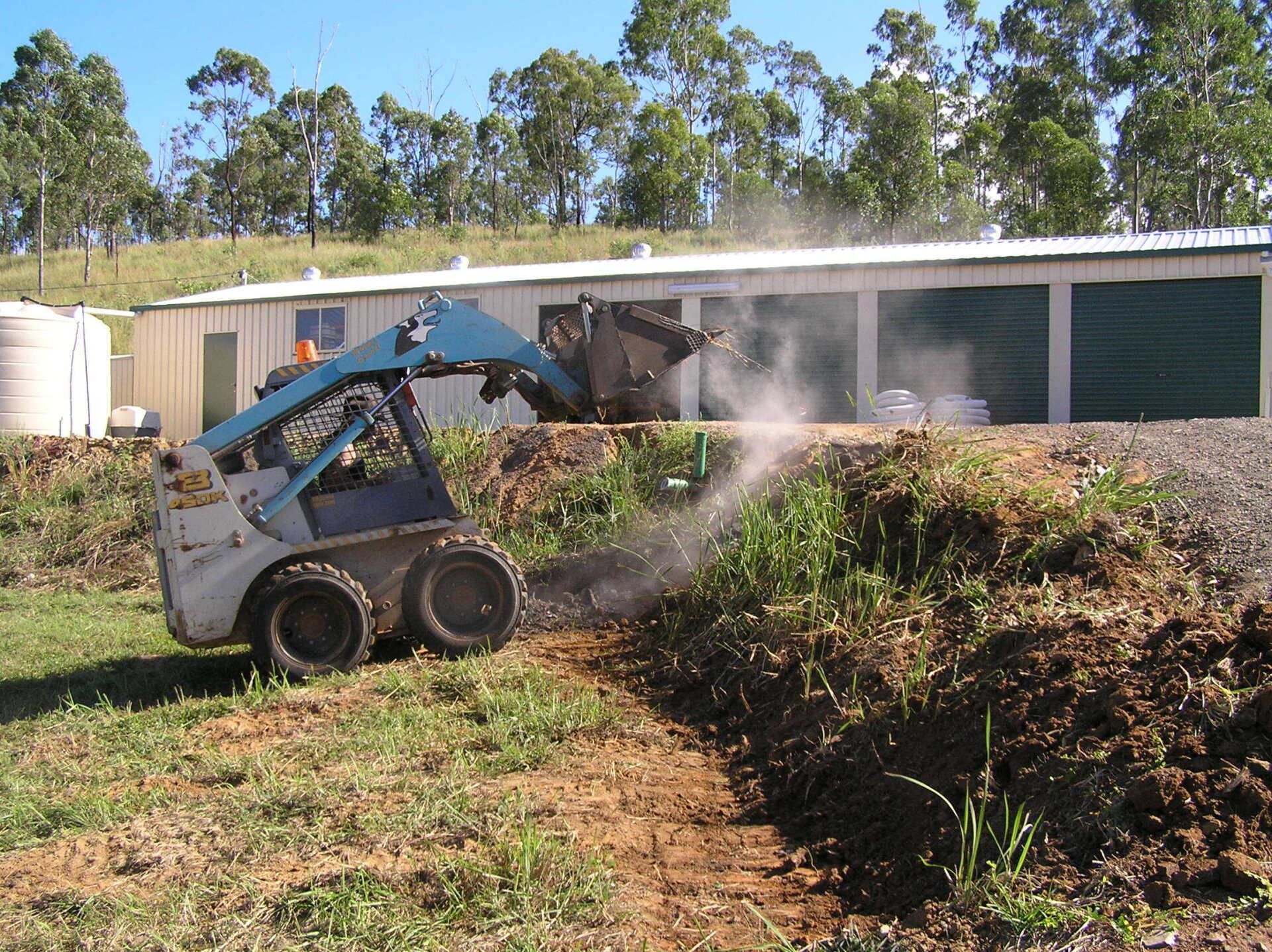 A Small, Blue Skid Steer Operating Outdoors — A1 Rock This City Truck & Dog Hire In Good Night, QLD