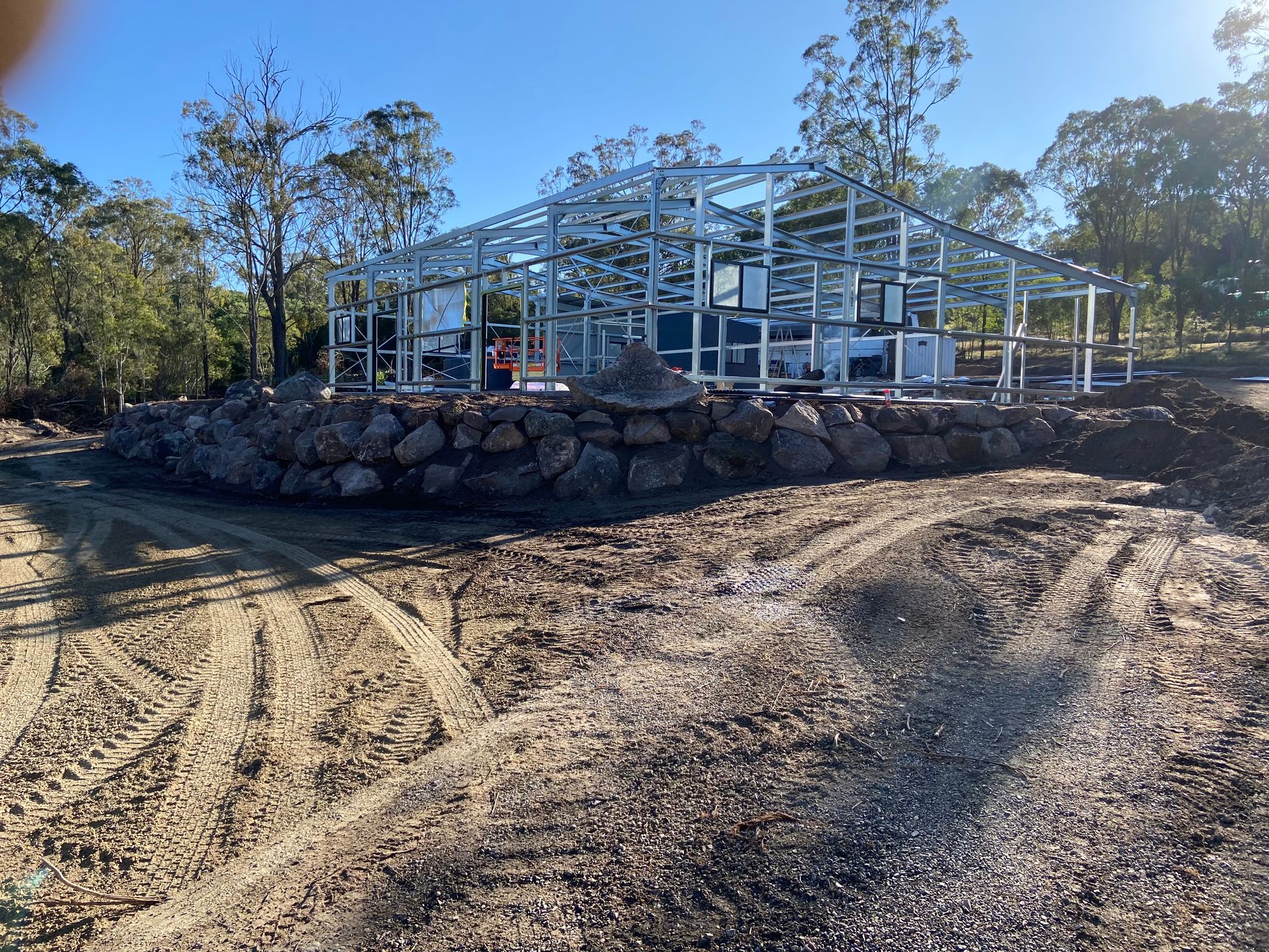 Construction Site: Steel Frame Structure on A Rock Retaining Wall  — A1 Rock This City Truck & Dog Hire In Good Night, QLD