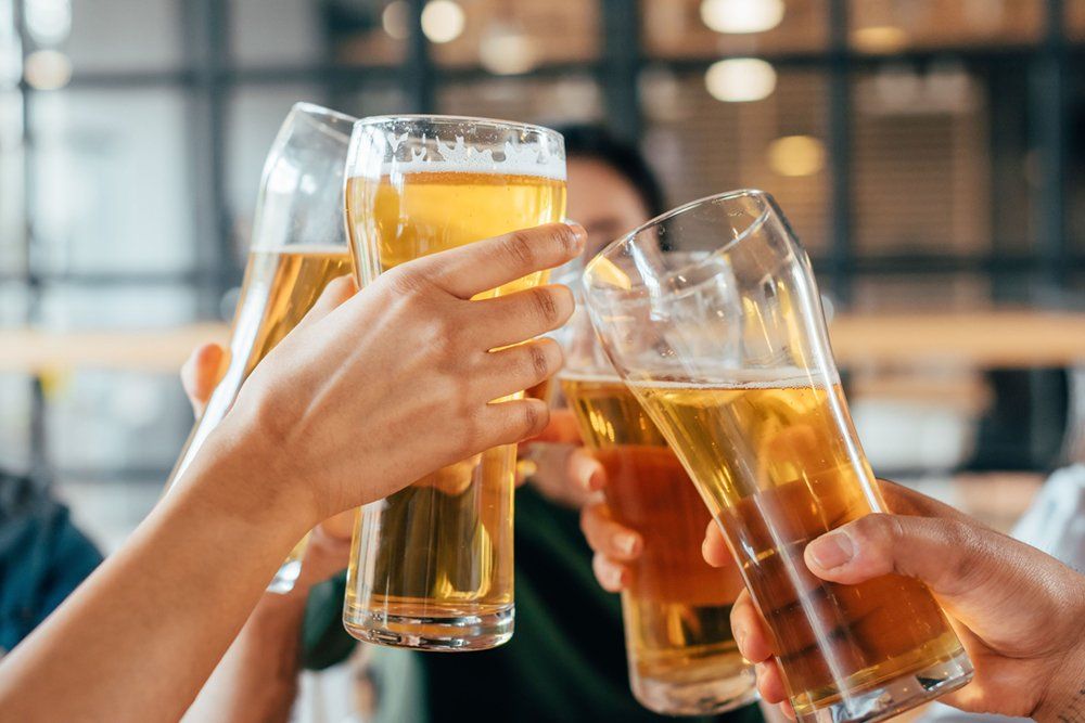 photo of people with beer glasses raised