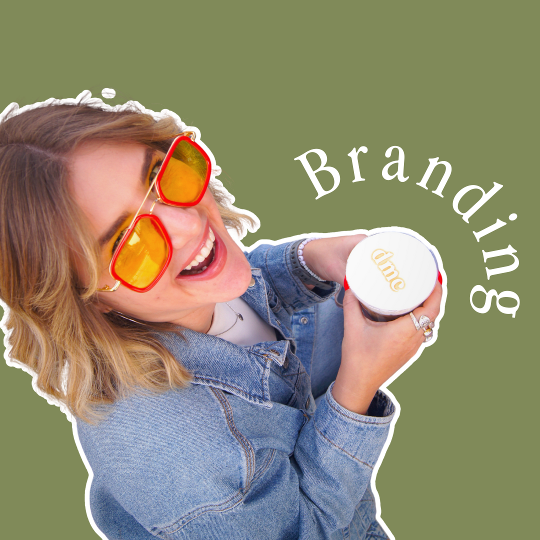 Woman in denim jacket, orange sunglasses, smiles, holds coffee, laptop, outdoor cafe.