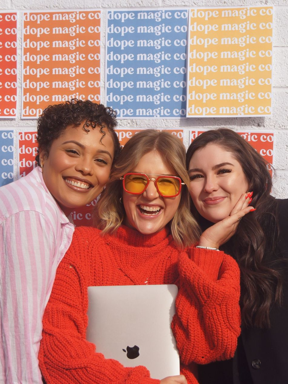 A woman is jumping in the air while holding a laptop.