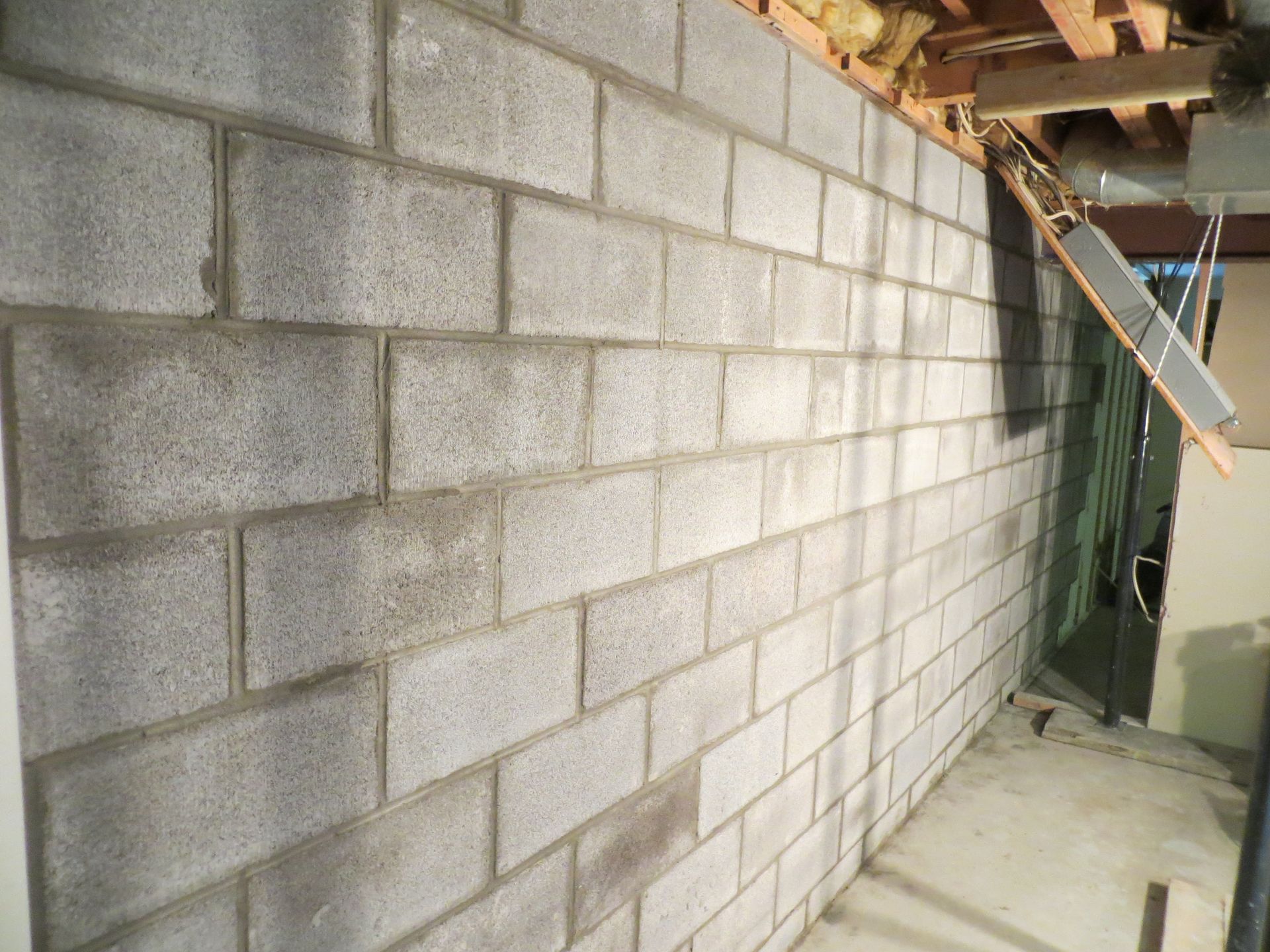 Gray cinder block wall in a basement setting.