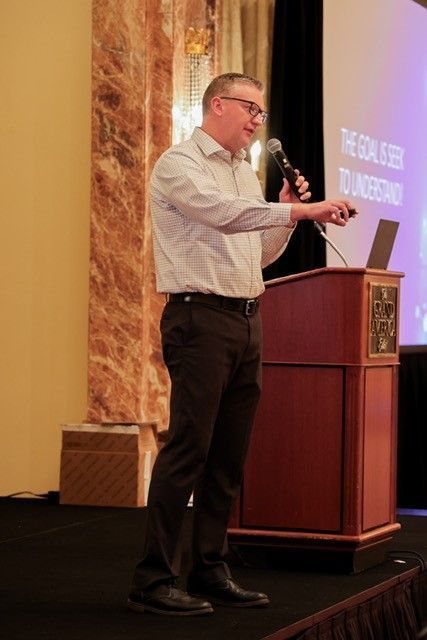 A man is standing at a podium giving a presentation.