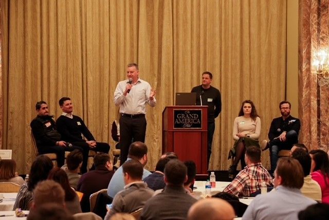 A man is standing at a podium giving a presentation to a group of people.