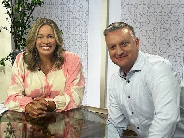A man and a woman are sitting at a table and smiling.