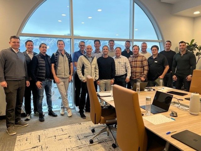 A group of men are posing for a picture in a conference room.