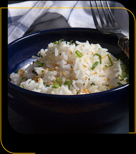 Un recipiente azul lleno de arroz blanco y cebollas verdes.