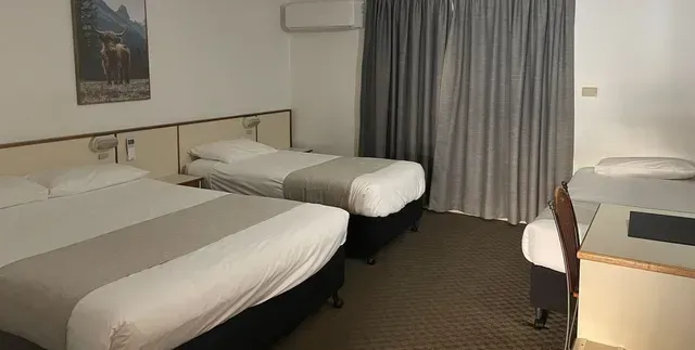 A Hotel Room With Two Beds and a Desk — Country Comfort Gin Gin Wild Scotsman Motor Inn in Gin Gin, QLD