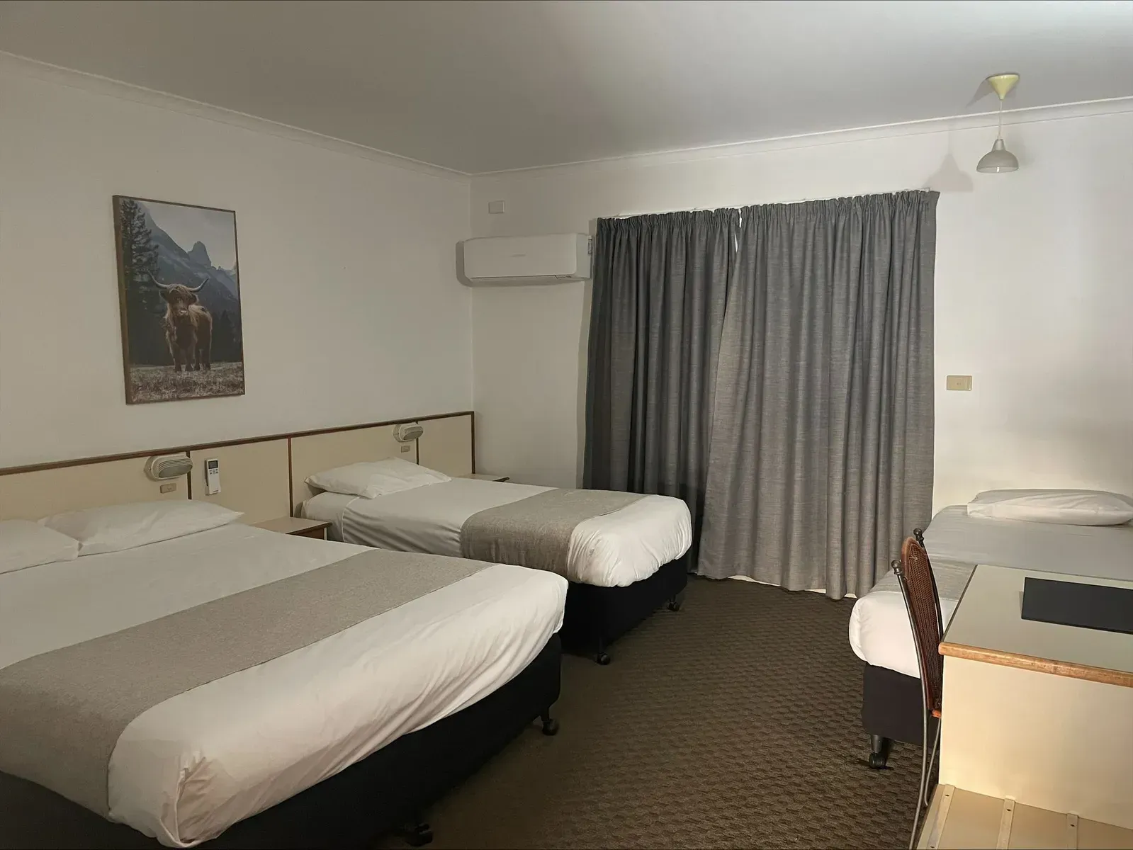 Two Beds in a Hotel Room With a Desk and Chair — Country Comfort Gin Gin Wild Scotsman Motor Inn in Gin Gin, QLD