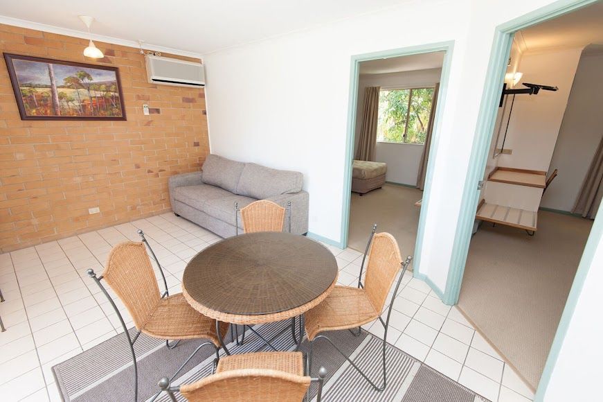 A Living Room With a Table and Chairs and a Couch — Country Comfort Gin Gin Wild Scotsman Motor Inn in Gin Gin, QLD