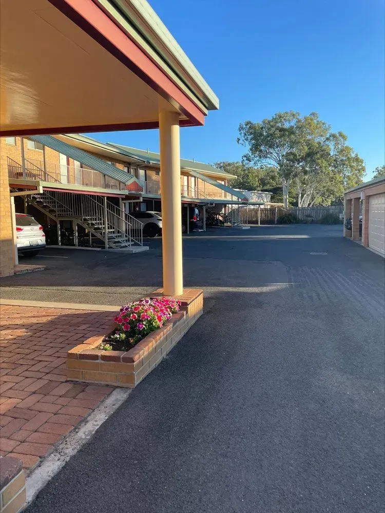 A Parking Lot in Front of a Building With Cars Parked Under a Canopy — Country Comfort Gin Gin Wild Scotsman Motor Inn in Gin Gin, QLD