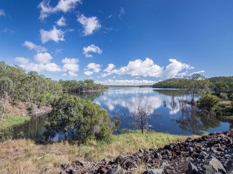 A Large Body of Water Surrounded by Trees and Rocks on a Sunny Day — Country Comfort Gin Gin Wild Scotsman Motor Inn in Gin Gin, QLD