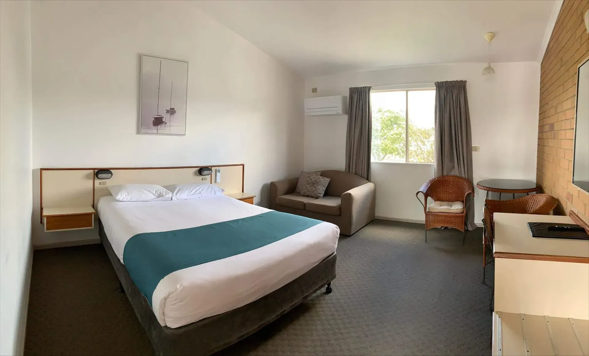 A Hotel Room Featuring a Bed, a Chair, and a Television — Country Comfort Gin Gin Wild Scotsman Motor Inn in Gin Gin, QLD