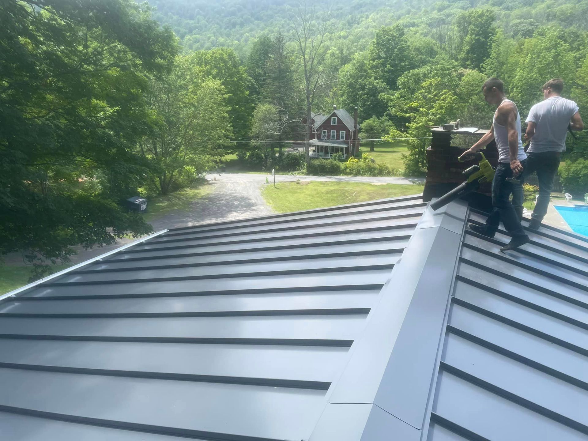 Two men are standing on the roof of a house.