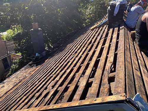 A group of people are working on a wooden roof.