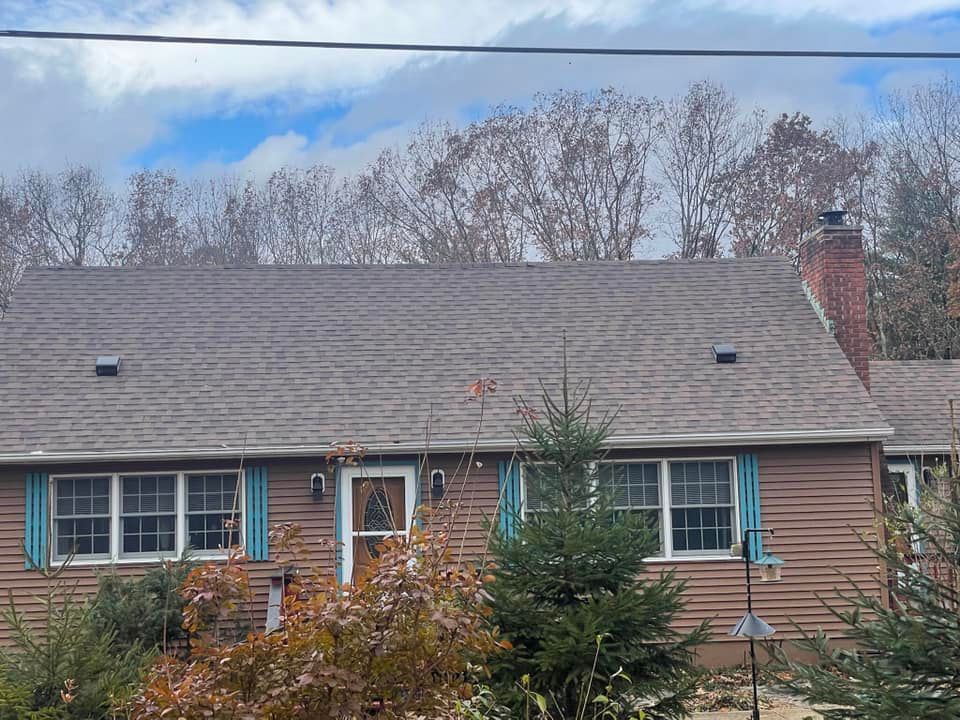 A house with a roof that is covered in shingles and a chimney.