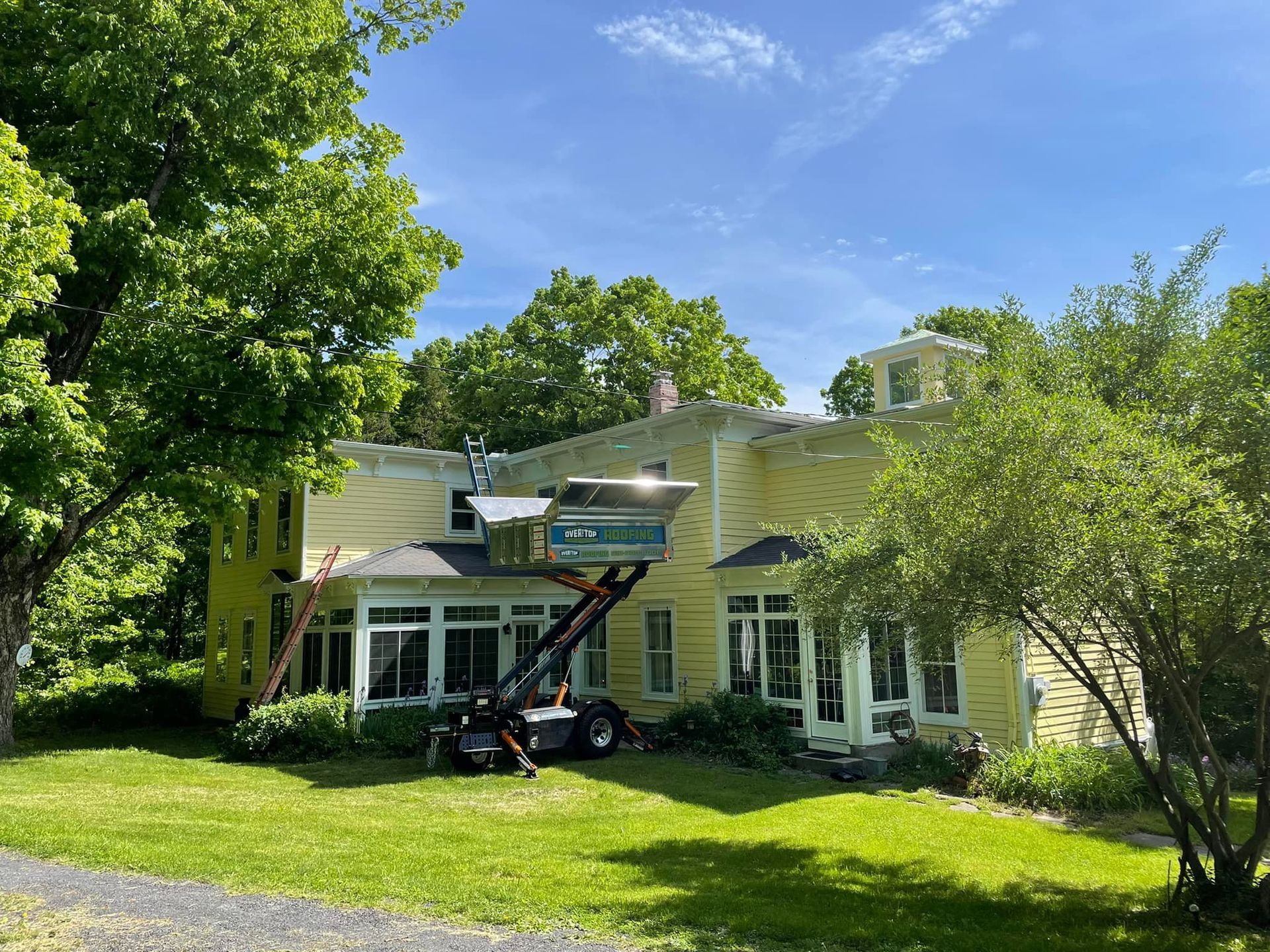 A yellow house with a crane on top of it.