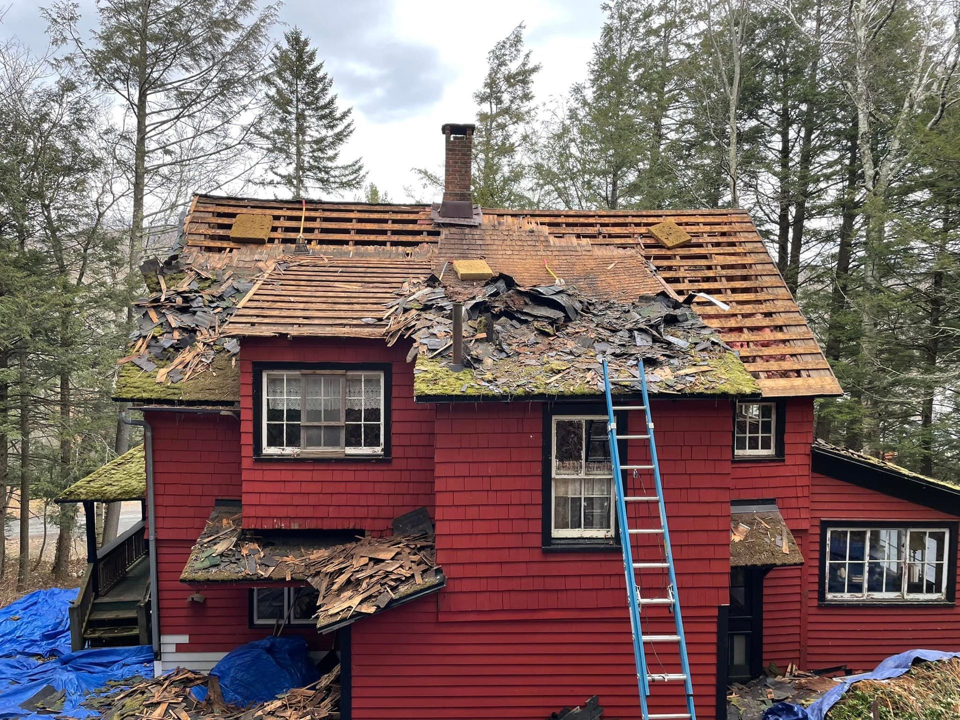 A red house with a ladder on the side of it.